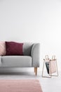 Purple and pastel pink pillow on the grey couch, real photo with copy space on the empty white wall Royalty Free Stock Photo