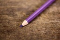 Purple pencil on old wooden table