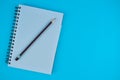 Purple pencil on top of a white opened diary before a light blue background Royalty Free Stock Photo