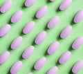 Purple pills on green background Royalty Free Stock Photo