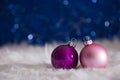 Purple and pink Christmas balls on white fur with garland lights Royalty Free Stock Photo