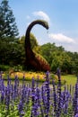 purple plant in front of the dinosaur statue
