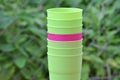 Purple plastic cup between green ones