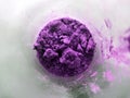 Purple powder in glass cup, bowl with ingredient close up. colored granules in transparent container. Magic fantasy powder.