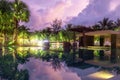 The purple reflection of the sky in the water in the evening. Palm trees, green plants and a beautiful sunset. hotel in Khao Lak, Royalty Free Stock Photo