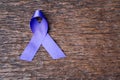 Purple ribbon for the awareness about the unacceptability of the violence against women on dark gray rustic wooden surface. Top Royalty Free Stock Photo