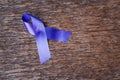 Purple ribbon for the awareness about the unacceptability of the violence against women on dark gray rustic wooden surface. Top Royalty Free Stock Photo