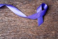 Purple ribbon for the awareness about the unacceptability of the violence against women on dark gray rustic wooden surface. Top Royalty Free Stock Photo