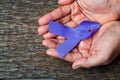 Purple ribbon for the awareness about the unacceptability of the violence against women on dark gray rustic wooden surface. Top Royalty Free Stock Photo