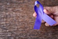 Purple ribbon for the awareness about the unacceptability of the violence against women on dark gray rustic wooden surface. Top Royalty Free Stock Photo