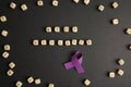 Purple ribbon and phrase STOP VIOLENCE made of cubes on black background, flat lay Royalty Free Stock Photo