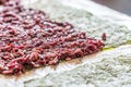 Purple Rice on a sheet of seaweed ready for a vegan sushi meal