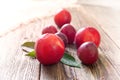 Purple ripe plums lie on a wooden table