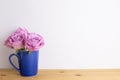 Purple rose flowers in ceramic cup on wooden table with white background Royalty Free Stock Photo