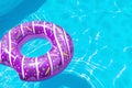 Purple rubber ring float floating in a refreshing blue swimming pool. Summer vacation in a hotel Royalty Free Stock Photo