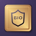 Purple Shield for bio green healthy food icon isolated on purple background. Organic product. Healthy food sticker. Gold