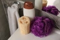 Purple shower puff, loofah sponge and bottle of body wash gel on sink in bathroom Royalty Free Stock Photo