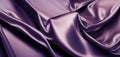 Purple silk satin fabric background. Wavy soft folds of purple fabric. Shiny fabric surface
