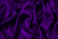 Purple silk satin fabric. Elegant abstract background in magenta colors. Liquid wave or silk wavy folds. Royalty Free Stock Photo