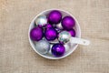 Purple and silver Christmas baubles in white bowl with spoon. Creative Christmas background Royalty Free Stock Photo