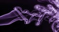 Purple smoke swirling on black background Royalty Free Stock Photo