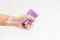 A purple sponge for washing dishes in a womanâs hand on a light background