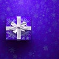 Purple square gift box wrapped in red paper with a white ribbon bow against a red snow background. Royalty Free Stock Photo