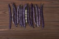 Purple string beans on a wooden background