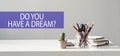 Purple strip with text DO YOU HAVE A DREAM on white desk next to office tools and a cactus Royalty Free Stock Photo