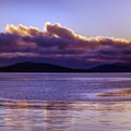 Purple sunset with clouds reflected in the sea. Royalty Free Stock Photo