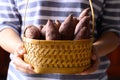 Purple sweet potato in basket holding by woman hand