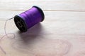 Purple thread spool with copy space isolated on wooden background closeup Royalty Free Stock Photo