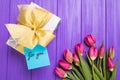 Purple tulip bouquet, blank greeting card for you and gift boxes. Top view over purple wooden table Royalty Free Stock Photo
