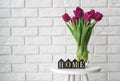 Purple tulips in a glass jar and wooden letters arranged into a word Home Royalty Free Stock Photo