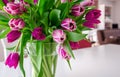 Purple tulips in a glass vase in bright living room