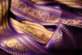Purple violet Indian Sari border with gold paisley pattern. purple background Royalty Free Stock Photo