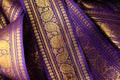 Purple violet Indian Sari border with gold paisley pattern. purple background Royalty Free Stock Photo