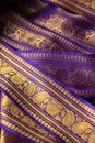 Purple violet Indian Sari border with gold paisley pattern. purple background Royalty Free Stock Photo