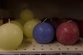 Purple, violet and yellow round candles on supermarket shelf. Decorative candles for present or celebration