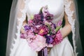 Purple wedding bouquet with fresh  lilacs, peonies, tulips in hands of bride Royalty Free Stock Photo