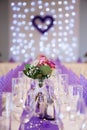 Purple wedding table decoration with focus on flower centerpiece