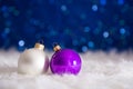 Purple and white Christmas balls on fur with garland lights on b Royalty Free Stock Photo