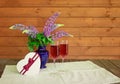 Purple wildflowers lupine, glasses of rose champagne and heart shape gift box on aged wooden table. Selective focus Royalty Free Stock Photo