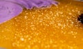 Purple yellow caramel mass with grains of sugar. Cooking sweet candy. Handmade sweets. Background of sweet food