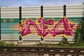 Purple,yellow and pink graffiti on a noise barrier wall