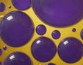 Purple and yellow soap bubbles in paint create an abstract design suitable for a colorful background Royalty Free Stock Photo