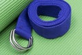 Purple Yoga Strap on Green Yoga Mat. Exercises for beginners