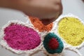 A woman preparing small Rangoli on tiled Floor