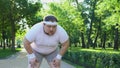 Purposeful fat man running in park, out of breath, persistent motivation