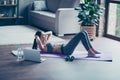 Purposeful strong athletic sportive beautiful attractive sportswoman lying on the floor and doing crunches stretching abs, she is